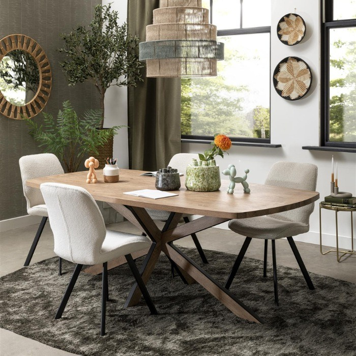 Sfeerbeeld van een woonkamer met de eetkamerstolen Semmi in de stof boucle rond  een tafel. 