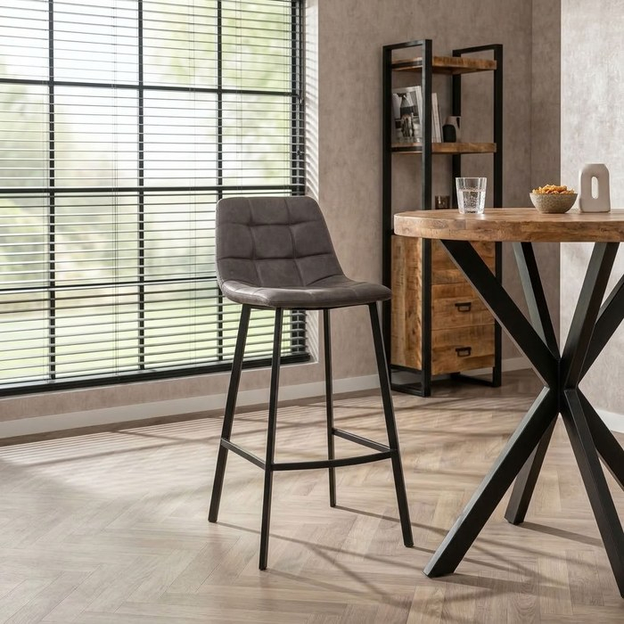 Barkruk grijs bij een ronde mangohouten bartafel met zwart onderstel