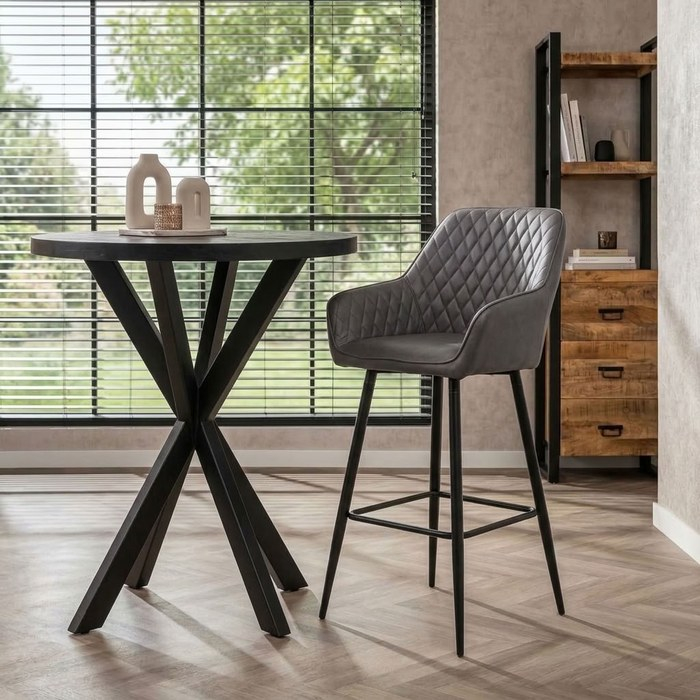 Barkruk grijs kunstleer bij een zwarte ronde bartafel met vaasjes