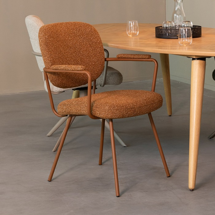 Eetkamerstoel Loek in cognac bouclé met armleuning aan de eettafel