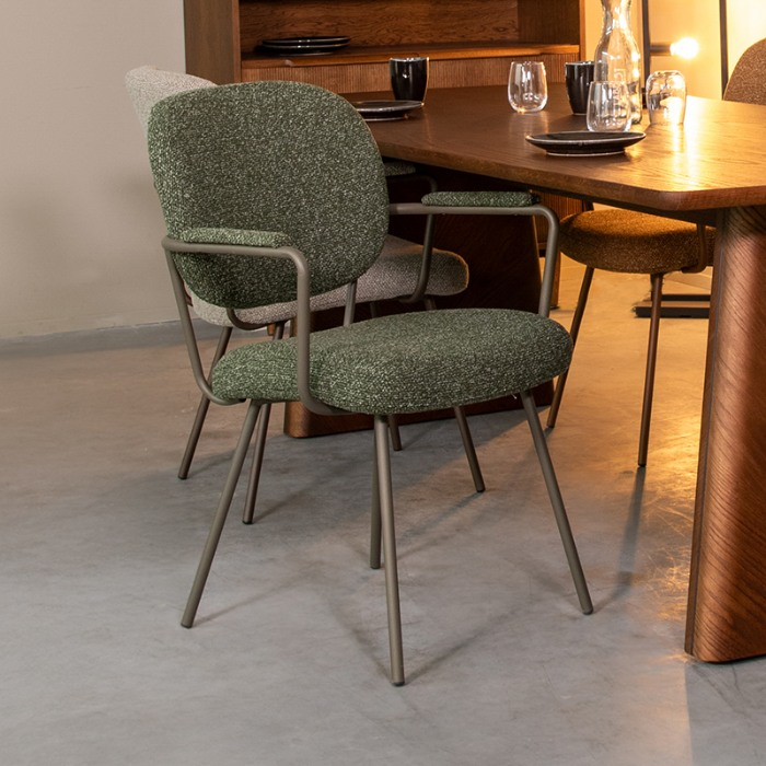 Eetkamerstoel Loek in groen bouclé met armleuning aan de eettafel