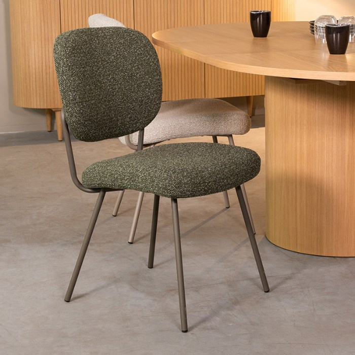 Eetkamerstoel Sem in groen bouclé met groene poten aan de eettafel