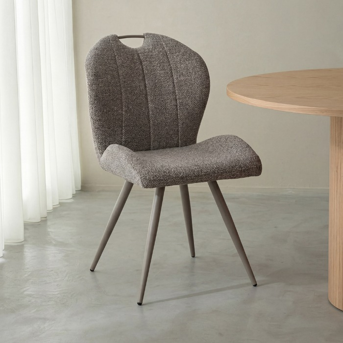 Eetkamerstoel Siem in grijs bouclé met handvat, taupe poten aan de eettafel