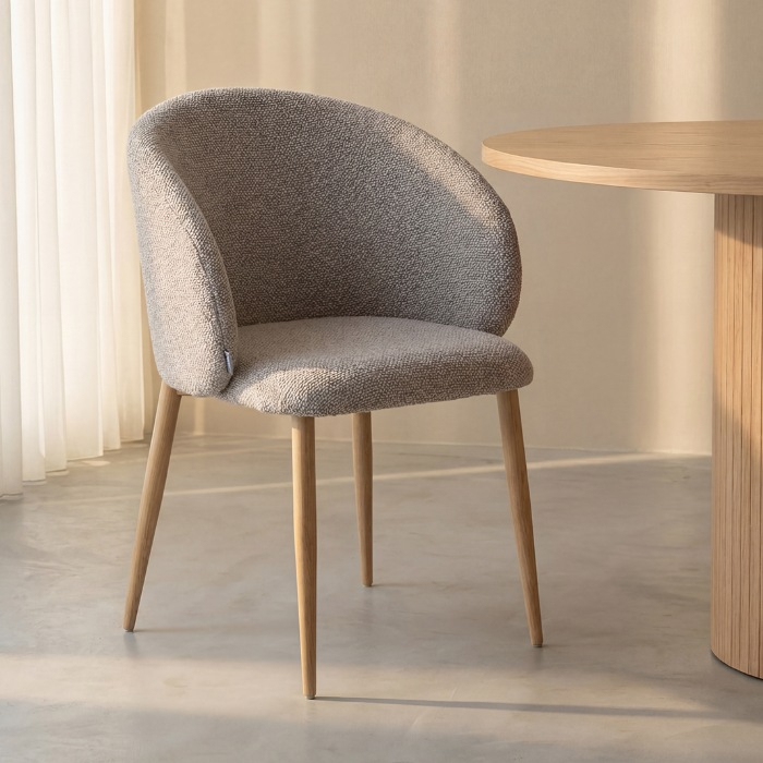 Bouclé eetkamerstoel Yorick in crème bouclé, poten met houtlook aan de eettafel