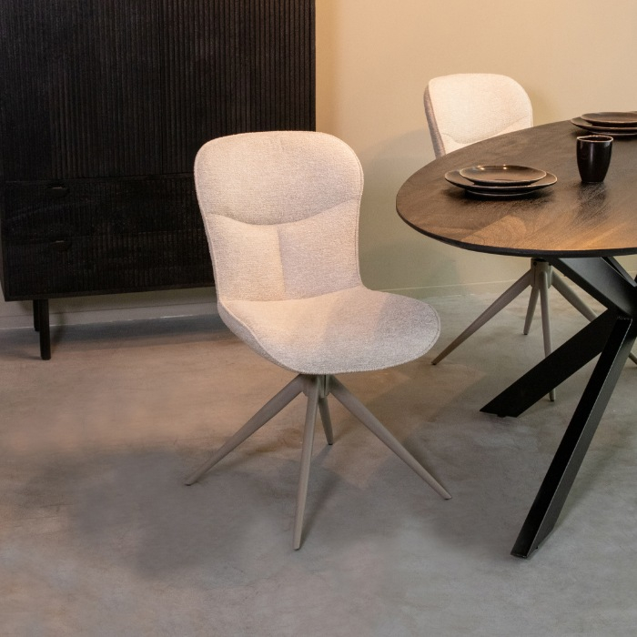 Draaibare eetkamerstoel Teun in lichtgrijs met taupe voet aan de eettafel