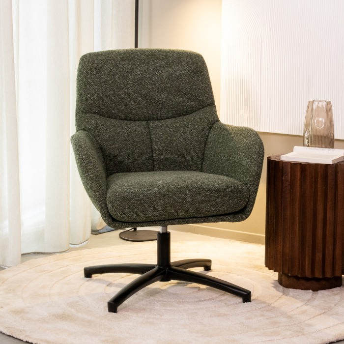 Draaifauteuil Carlijn in groen bouclé met armleuningen in een woonkamer