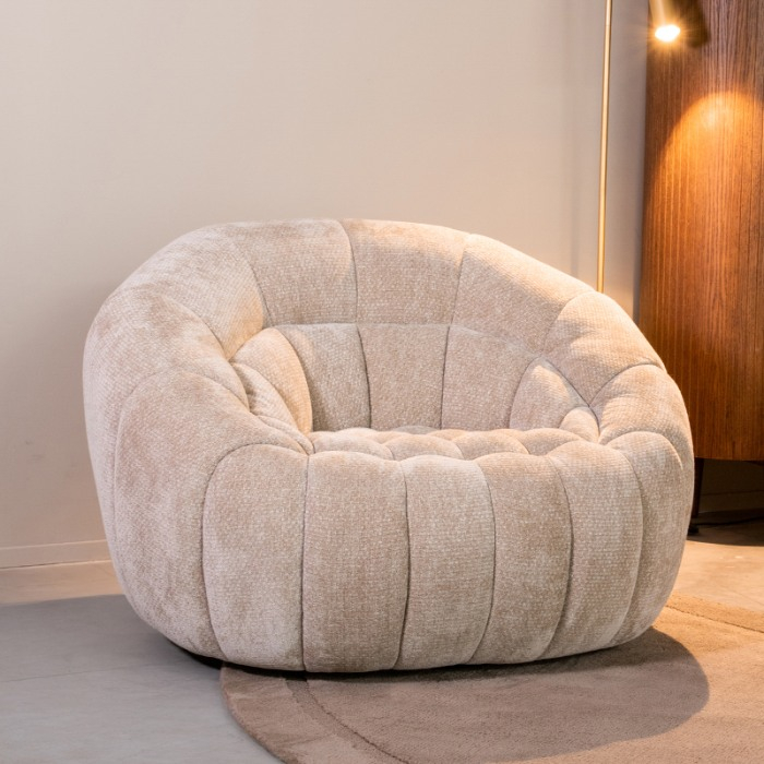 Draaifauteuil Dewi in beige met gestikte banen in een woonkamer