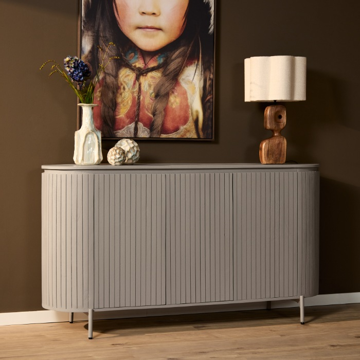 Taupe dressoir Solana met ribbelfront en afgeronde hoeken tegen een donkere wand
