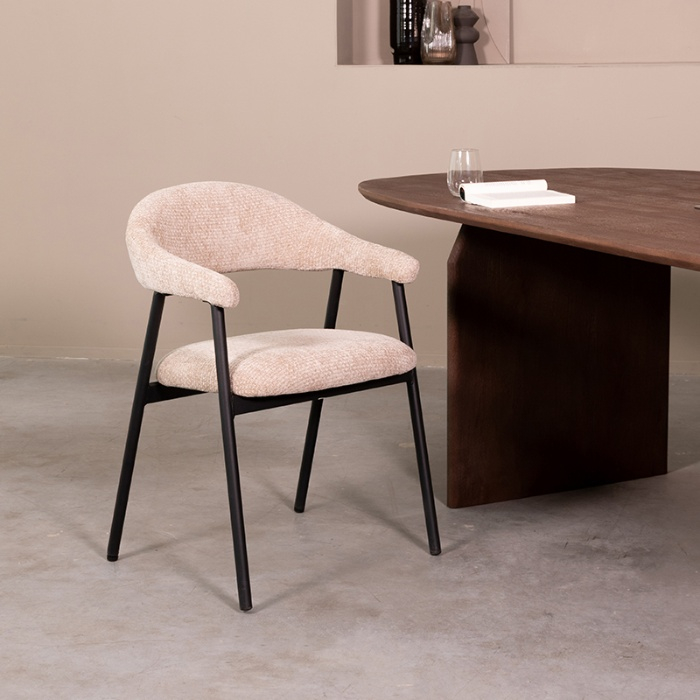 Eetkamerstoel met armleuning Arjen in beige met ronde rug en zwart frame aan de eettafel