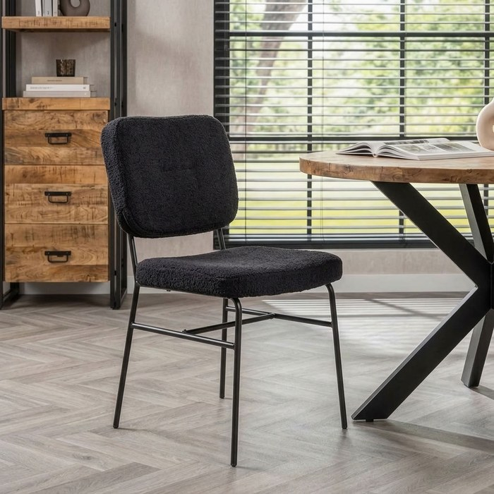 Eetkamerstoel teddy zwart in een industrieel interieur met mangohouten ladekast