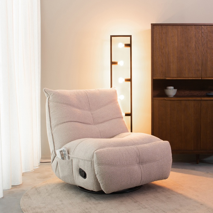 Relaxfauteuil Tijn in naturel bouclé met voetensteun in een woonkamer