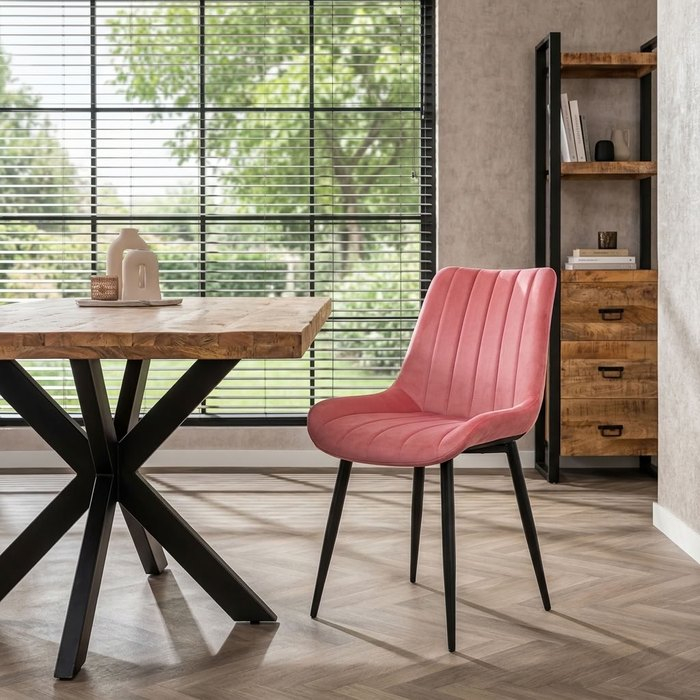 Roze velvet stoel naast een massief houten eettafel met matrix onderstel