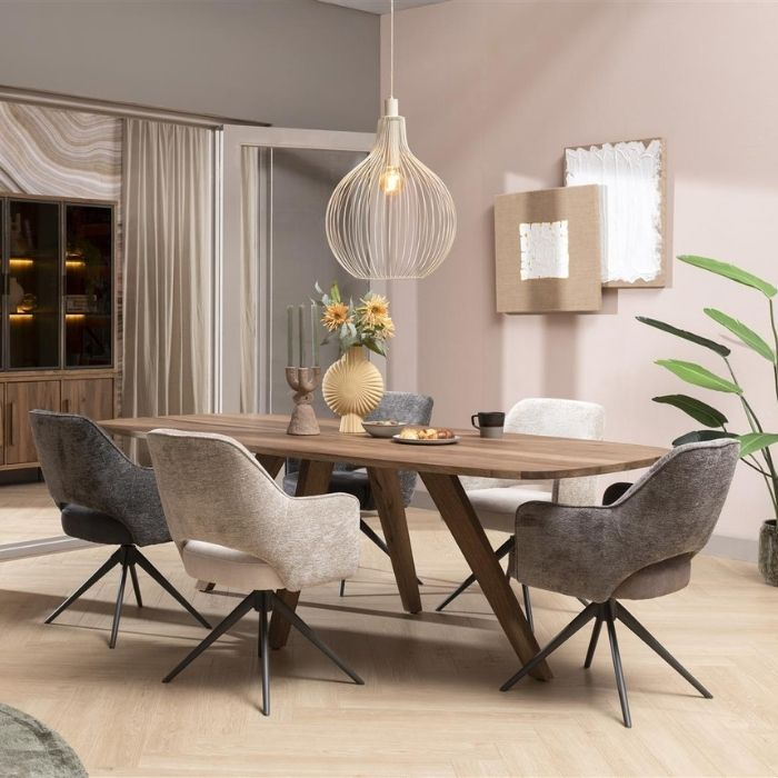 Sfeerafbeelding van de stoelen Brad in drie kleuren rond om een eettafel. 