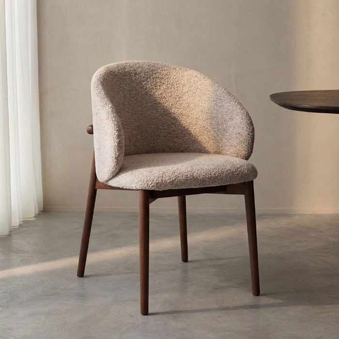 Stoffen eetkamerstoel Nikki in beige met walnoot houten poten aan de eettafel