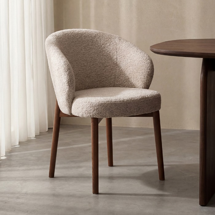 Stoffen eetkamerstoel Sophia in beige met walnoot eikenhouten poten aan de eettafel