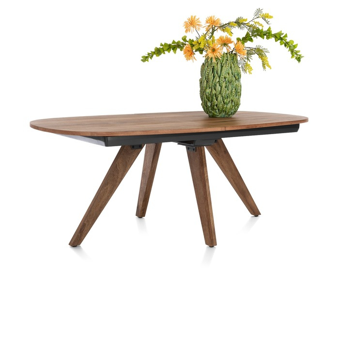 Uitschuifbare eettafel Everest 190 cm in mangohout met Deens ovaal blad op schuine houten poten, schuin aanzicht met vaas