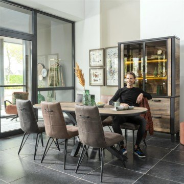 Sfeerbeeld van de eetkamerstoel bella met een man aan tafel. 