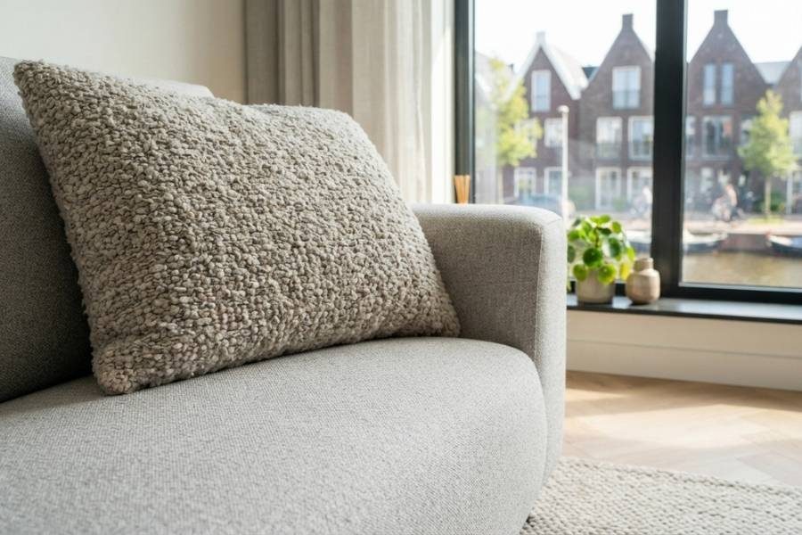 Chenille sierkussen op een bank van dezelfde stof