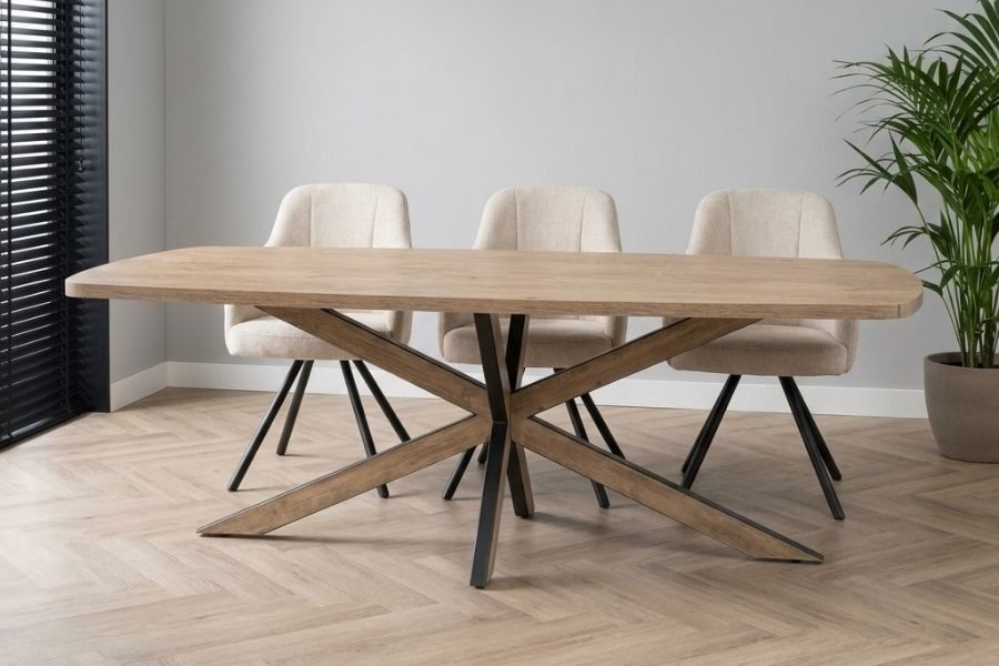Ovale houten eettafel met zwarte matrixpoot en beige eetkamerstoelen