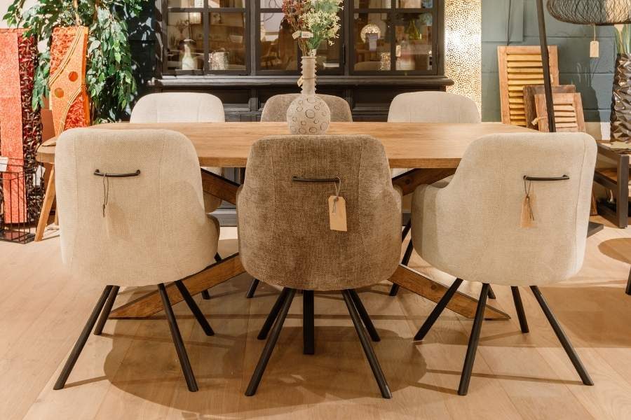 Eettafel met zes stoffen eetkamerstoelen in de showroom