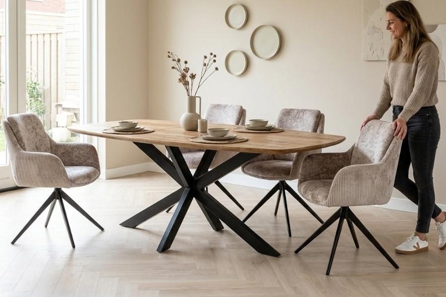 Ovale mangohouten eettafel met eetkamerstoelen in een lichte eetkamer