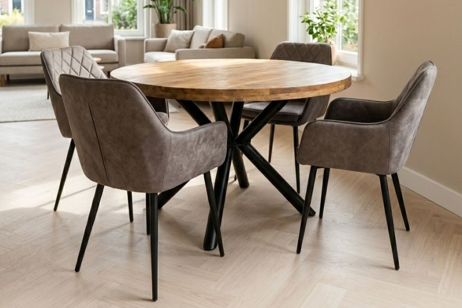 Ronde houten eettafel met zwart spinpootonderstel en leren eetkamerstoelen